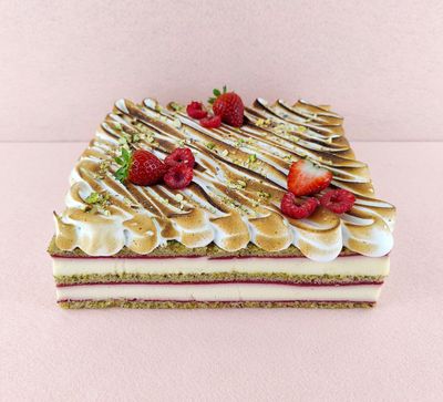 Tarta Ópera cuadrada para varias personas, fotografiada en ángulo de 45 grados, con cobertura de chocolate, cortes limpios donde se aprecian todas las capas y granos de café decorativos en la superficie.