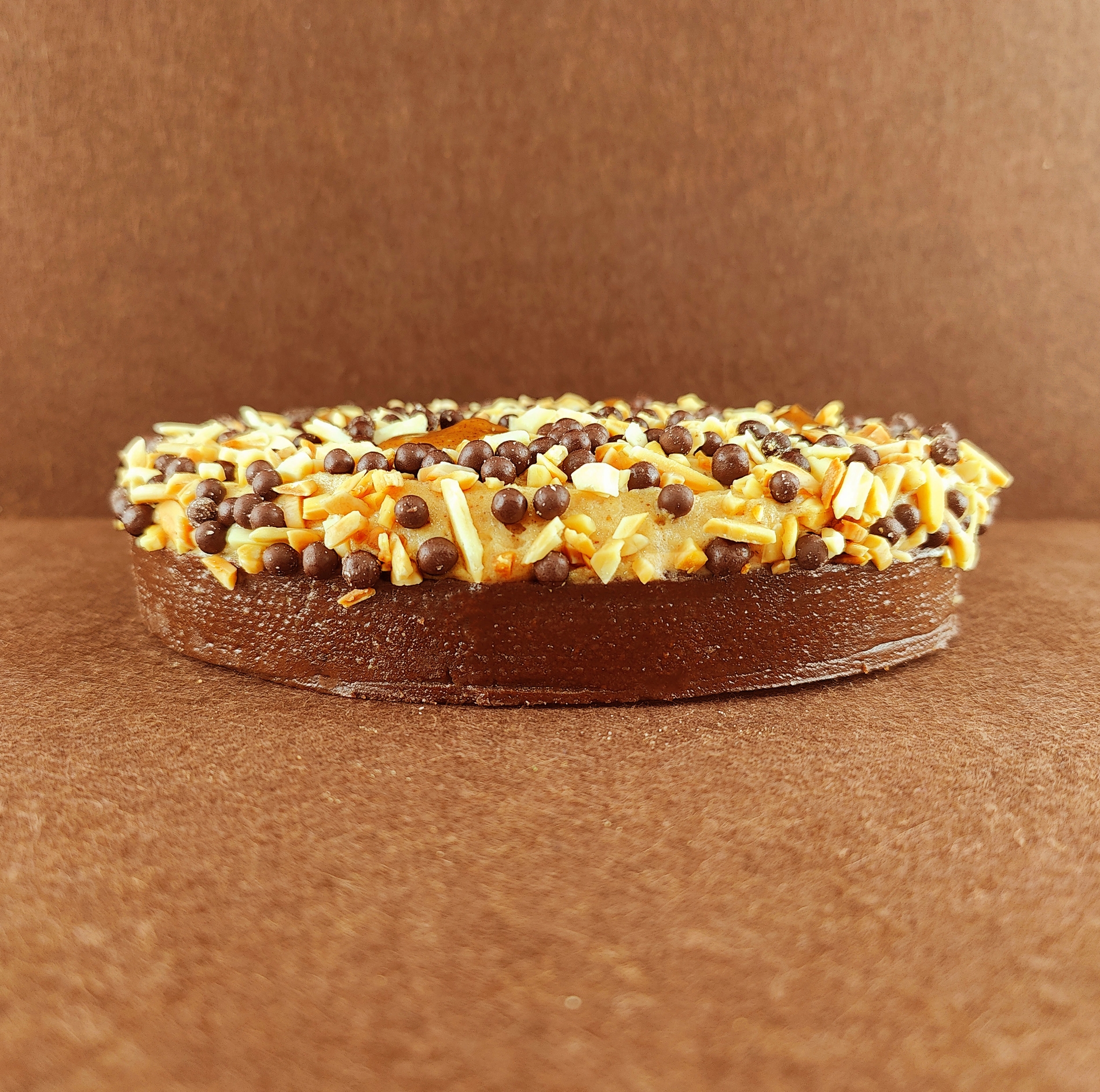 Tarta Ópera cuadrada vista de frente, mostrando claramente las capas alternas de bizcocho de almendra, crema de café y ganache de chocolate, con granos de café decorando la parte superior.