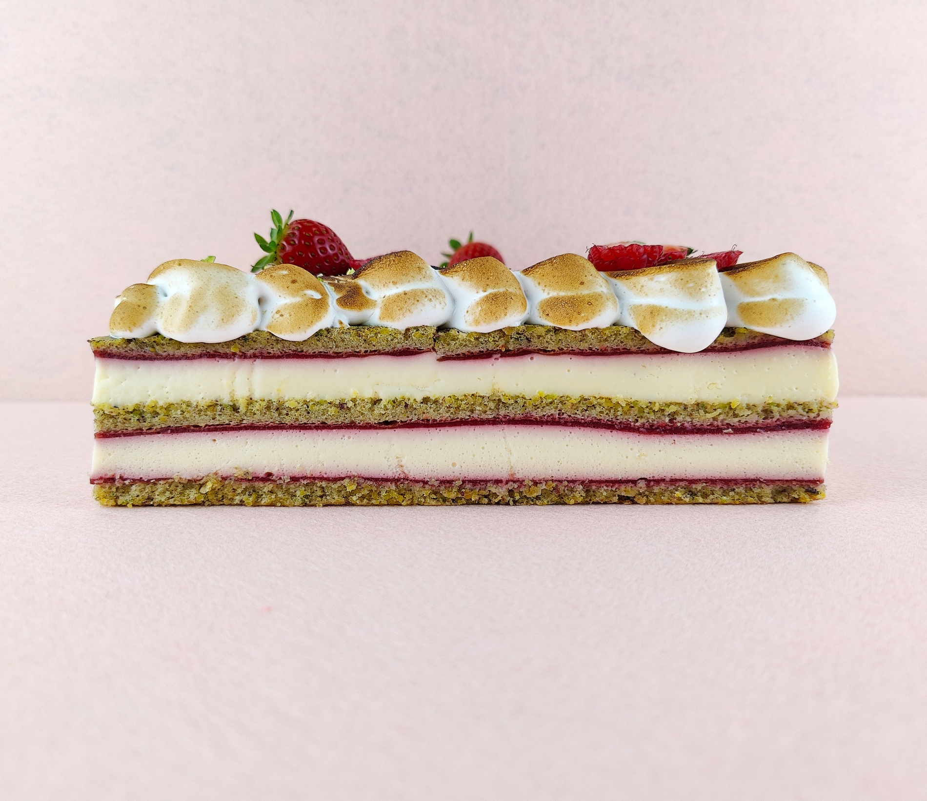 Tarta Ópera cuadrada vista de frente, mostrando claramente las capas alternas de bizcocho de almendra, crema de café y ganache de chocolate, con granos de café decorando la parte superior.