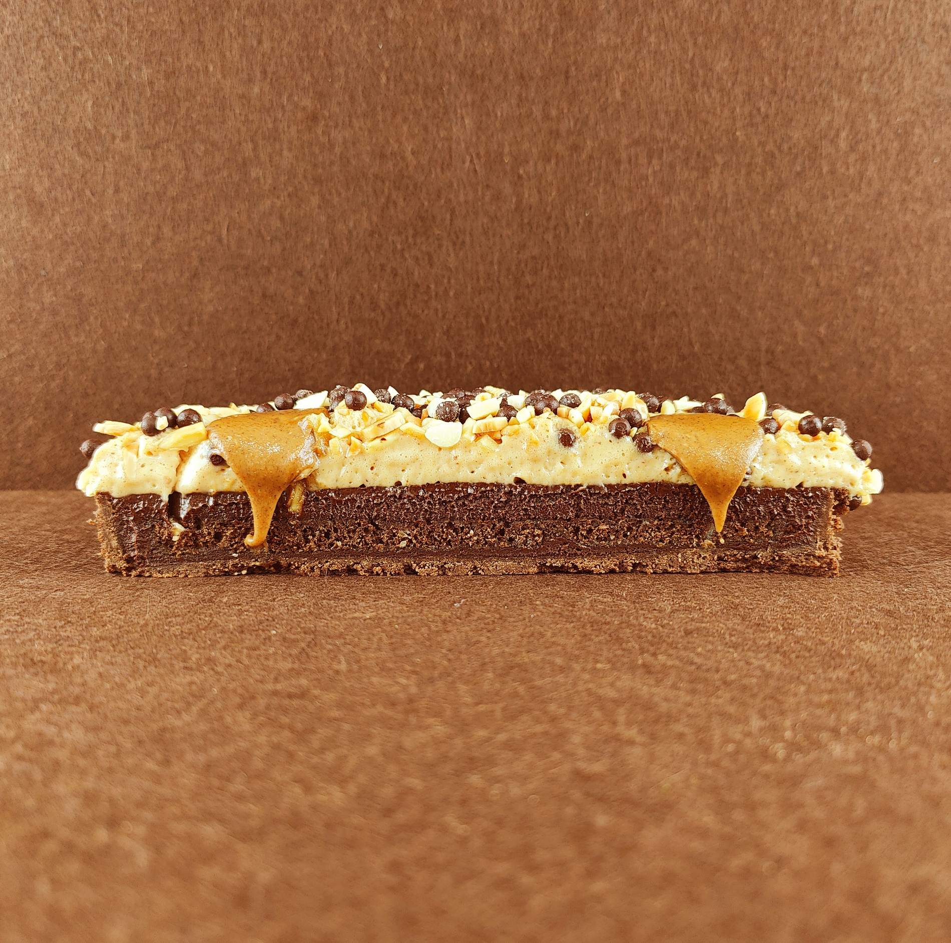 Primer plano de una Tarta Ópera cuadrada, resaltando la textura del glaseado chocolate, la suavidad de la crema de café, la cremosidad de la ganaché de chocolate y la esponjosidad del bizcocho gioconda empapado en café.