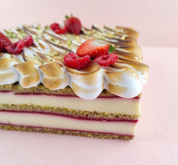 Primer plano de una Tarta Ópera cuadrada, resaltando la textura del glaseado chocolate, la suavidad de la crema de café, la cremosidad de la ganaché de chocolate y la esponjosidad del bizcocho gioconda empapado en café.