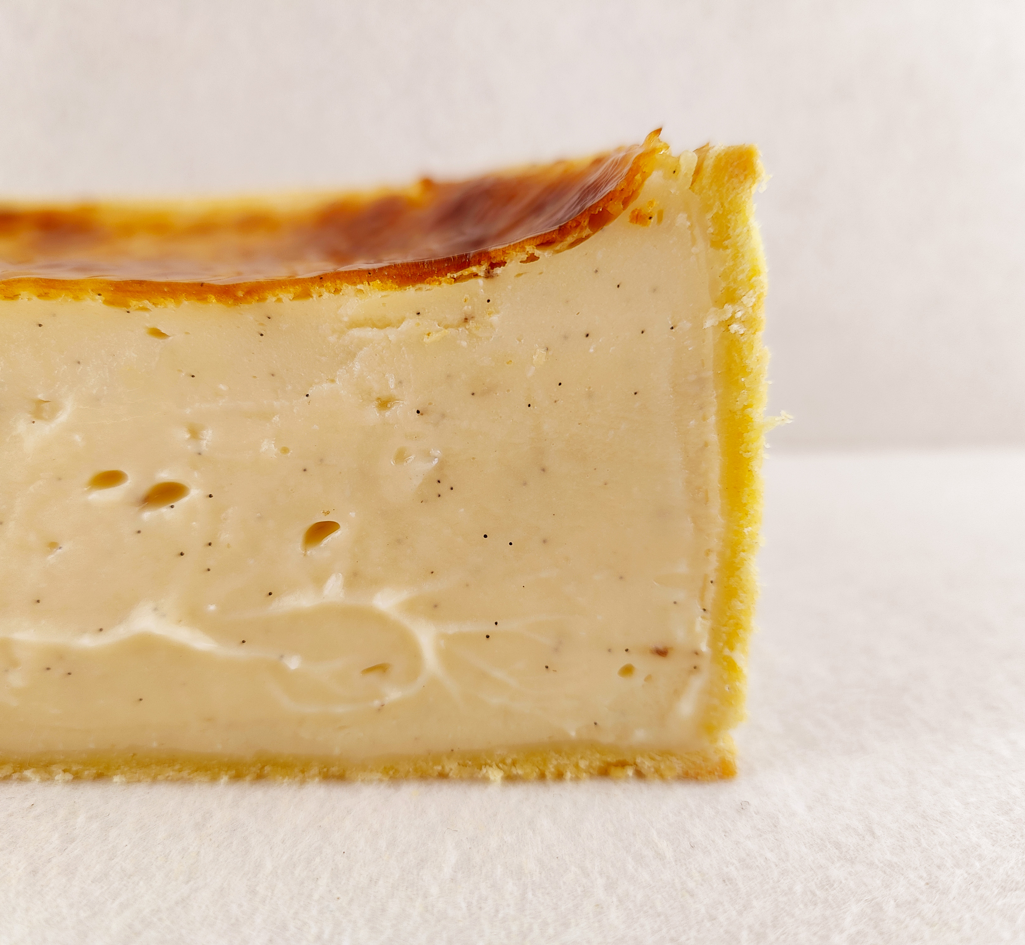 Primer plano del flan parisino a la vainilla, con textura cremosa, pequeños puntos de vainilla y superficie ligeramente tostada.