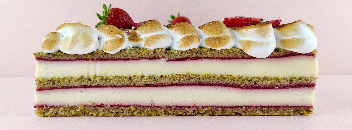 Primer plano de una porción rectangular de Tarta Ópera, destacando la textura lisa del glaseado de chocolate y la definición de las capas de bizcocho de almendra, crema de café y ganache de chocolate.