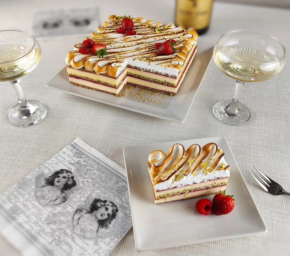 Image tomada desde arriba con un fondo blanco donde aparecen las distintas tartas que ofrece la tienda en distintos formatos: tarta Òpera, París Brest, Fraisier, Tropezienne y Chocolate y Praliné